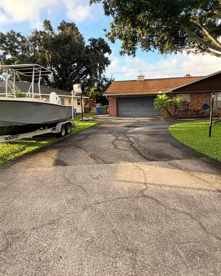 The garage end of the driveway before pressure washing: dark stains and tire marks