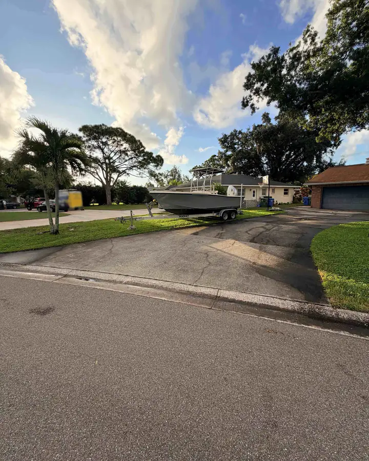 The driveway from the street before pressure washing: dark, blotchy concrete